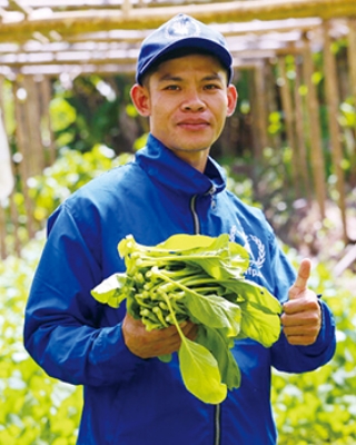 砲撃された建物の写真を手にするザフリュパニさん。
